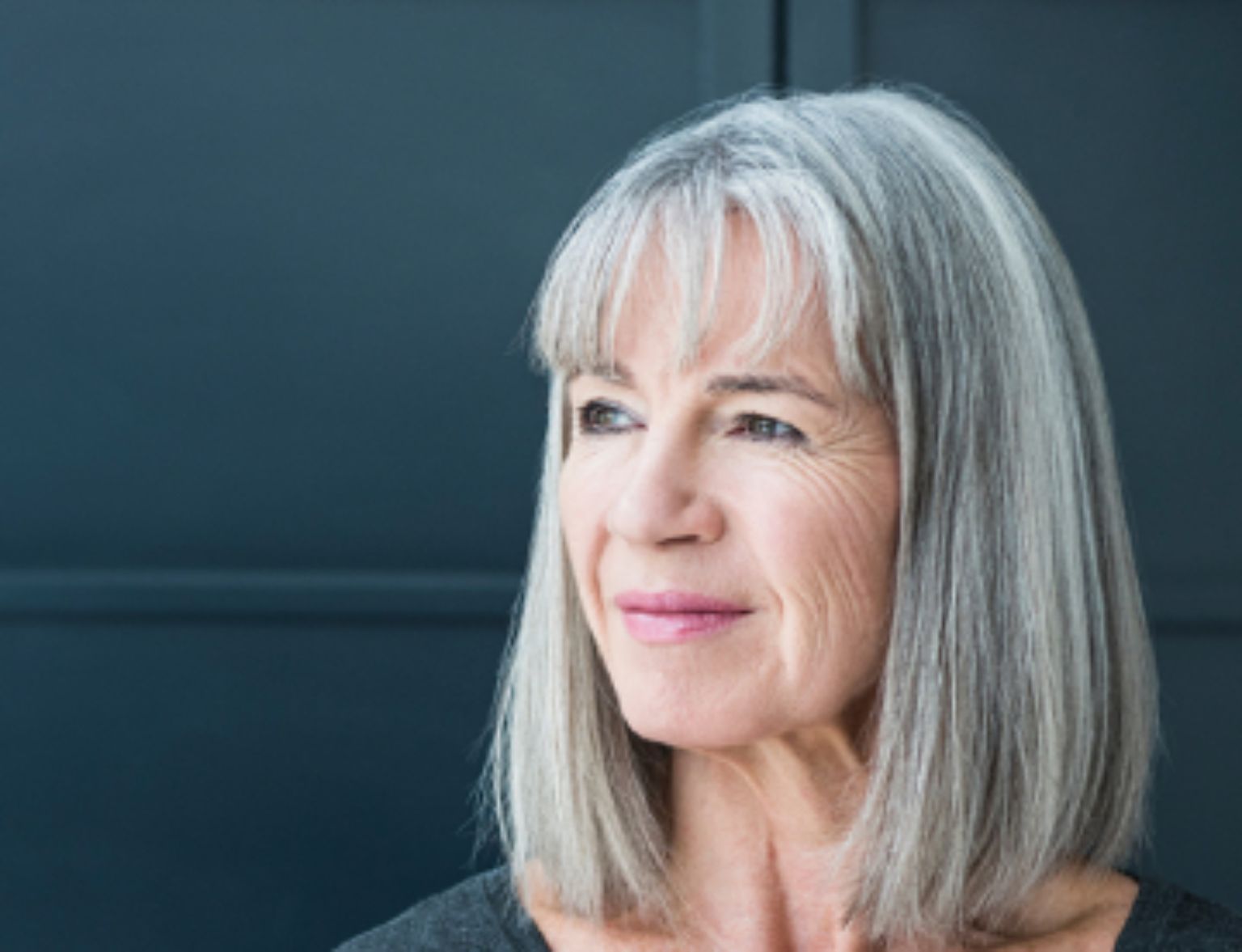 Blog Teaser - Frau vor dunklem Hintergrund